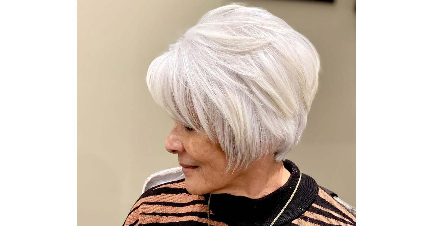 A stylish and modern haircut with a silver hue on an individual looking away from the camera.